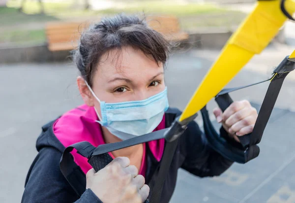 Asian young fitness sport woman training outside and wearing disposable medical mask. Dust and pollution and protection flu virus, influenza, coronavirus on city. Covid-19 person