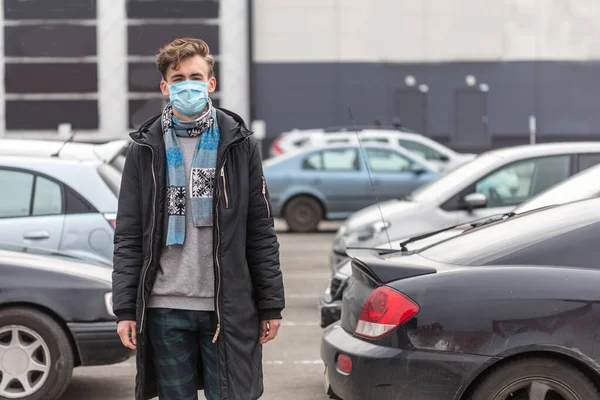 顔のマスクをした若い男コロナウイルスから身を守る Covid 19人 スーパーの近くの大きな駐車場に立ち コロナウイルスの状況の中で世界 — ストック写真