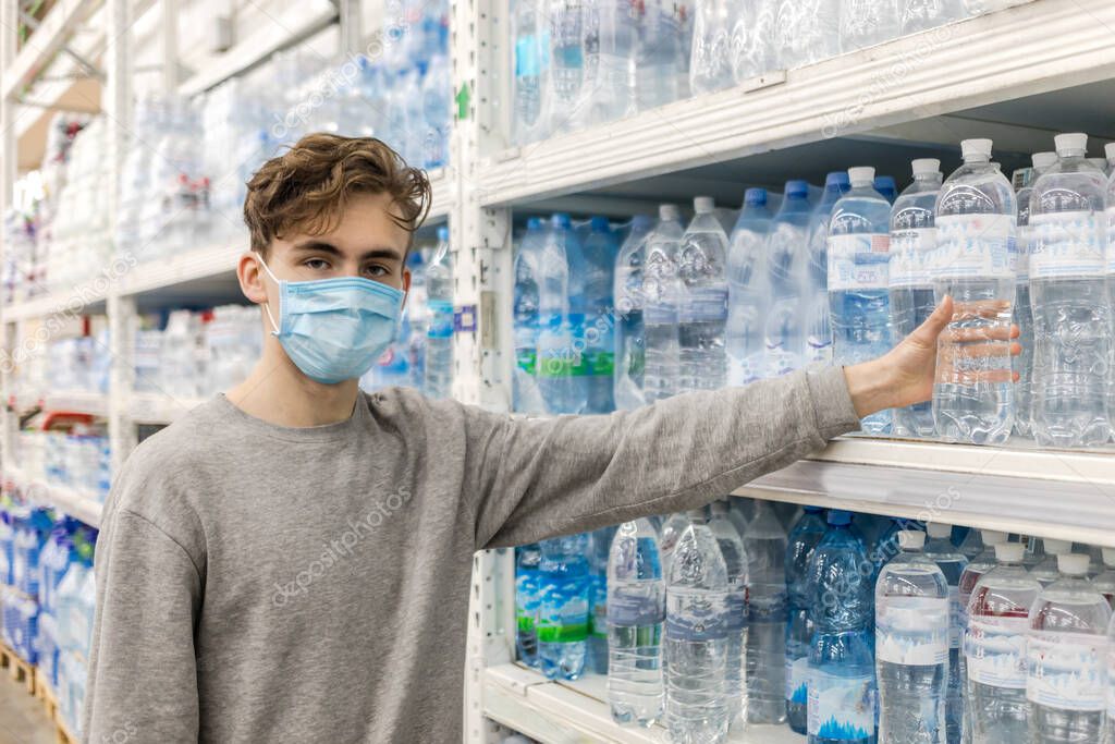 Young man wearing disposable medical mask shopping in supermarket during coronavirus pneumonia outbreak. Protection and prevent measures while epidemic time. Covid-19 person