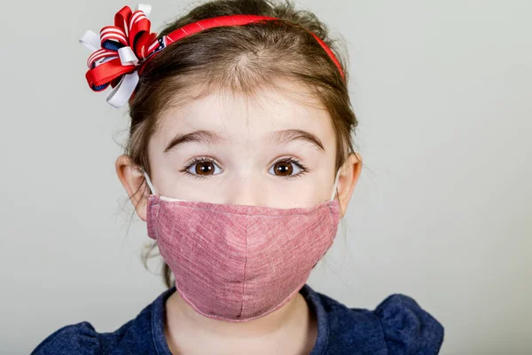 女の子はコロナウイルスCovid 19から身を守るファブリックマスクを持っています 安全屋外活動のための彼女の鼻の上にマスクを持つ子供 病気や大気汚染 — ストック写真