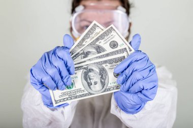 Koruyucu giysili doktor para tutuyor. Grip aşısı, koronavirüs, ebola..