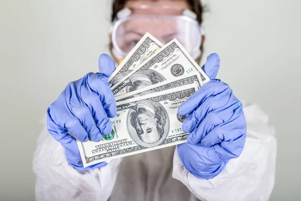 Koruyucu giysili doktor para tutuyor. Grip aşısı, koronavirüs, ebola..