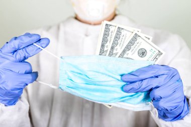 Coronavirus COVID-19 analizi için koruma maskesi ve para taşıyan bir doktor. Grip aşısı, koronavirüs, ebola..