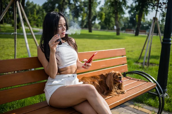 Attractive Woman Smoking Vape Device Reading News Phone Park — Stock Photo, Image