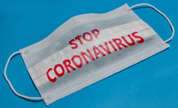 Medicinsk Ansiktsmask Med Stop Coronavirus Text Blå Bakgrund Begreppet Karantän — Stockfoto