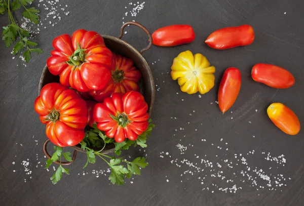 Tomates frescos sobre mesa negra — Foto de Stock