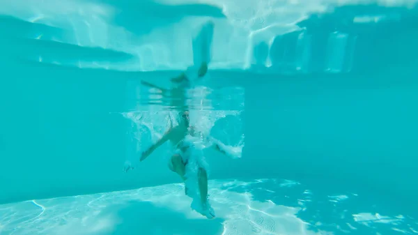 Vista subaquática do homem pulando em uma piscina — Fotografia de Stock