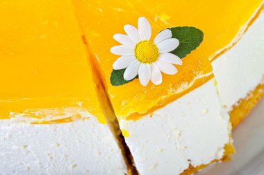 Elma reçeli, nane yaprağı ve papatyayla süslenmiş konsantre süt keki..