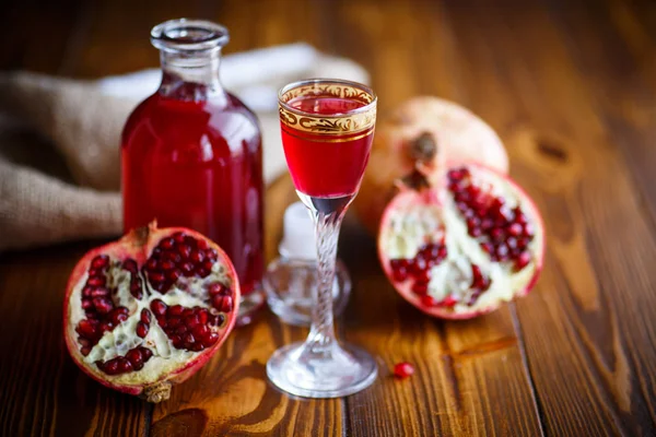 Sweet pomegranate alcoholic cordial in the decanter with a glass — Stock Photo, Image