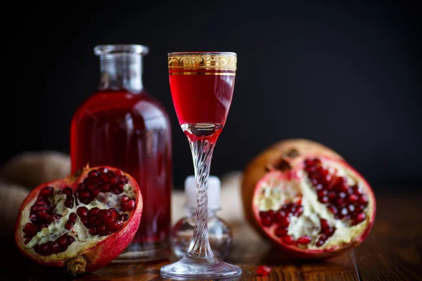 Sweet pomegranate alcoholic cordial in the decanter with a glass — Stock Photo, Image