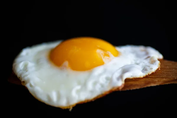 Gebakken ei met een houten lepel — Stockfoto