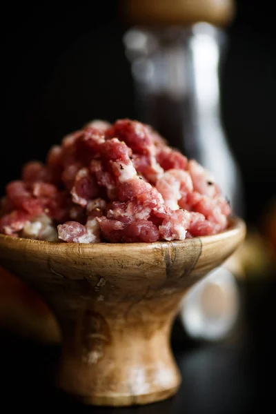 Chopped meat in a wooden bowl with spices — Stock Photo, Image