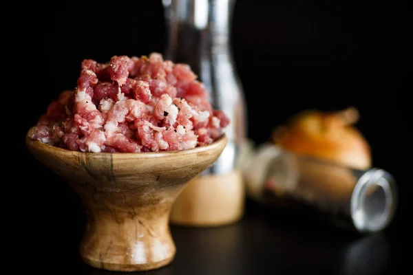 Chopped meat in a wooden bowl with spices — Stock Photo, Image