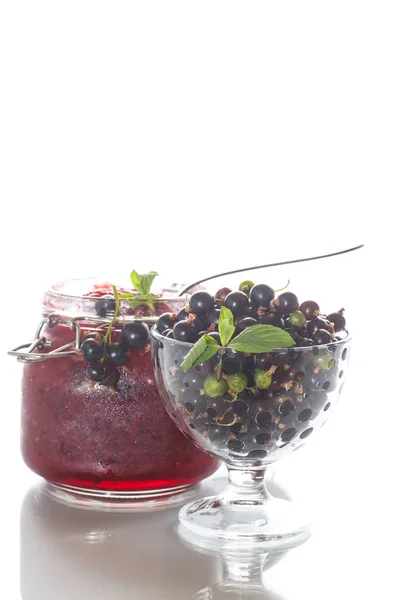 Спелые ягоды черной смородины с джемом — стоковое фото