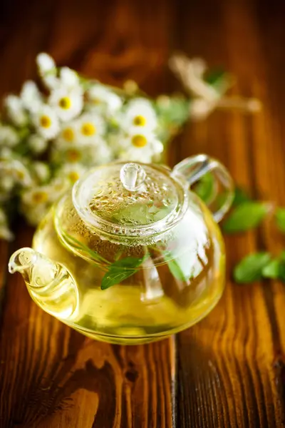 Glass teapot with chamomile tea — Stock Photo, Image