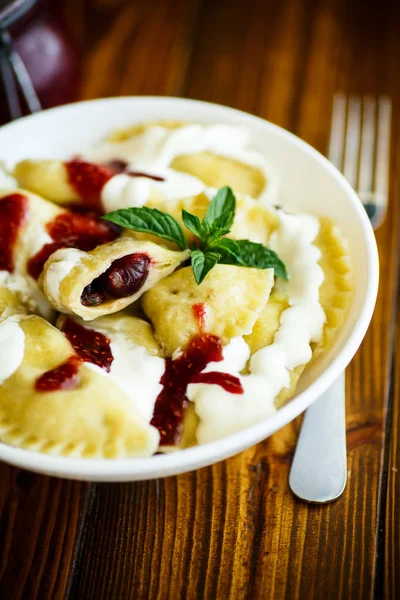 Домашние сладкие пельмени с ягодами и сметаной — стоковое фото