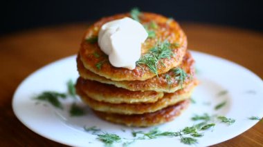 ahşap bir masa bir tabağa dereotu ile patates pancakes