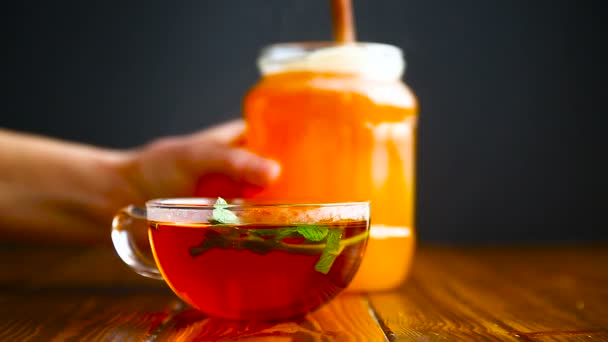 thé chaud avec du miel dans une tasse en verre 