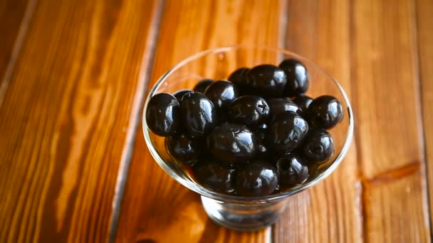 Черные оливки в стеклянной чаше — стоковое видео