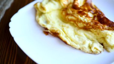 ahşap bir masa üzerinde bir tabak içinde kavrulmuş sabah omlet
