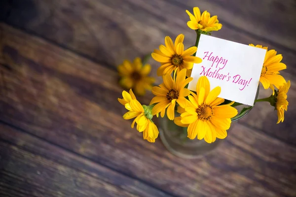 Strauß schön blühender Gänseblümchen auf einem Holztisch — Stockfoto