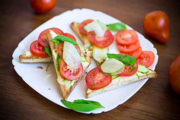 Sanduíche saboroso com pasta de coalhada, pepinos frescos e tomates — Fotografia de Stock