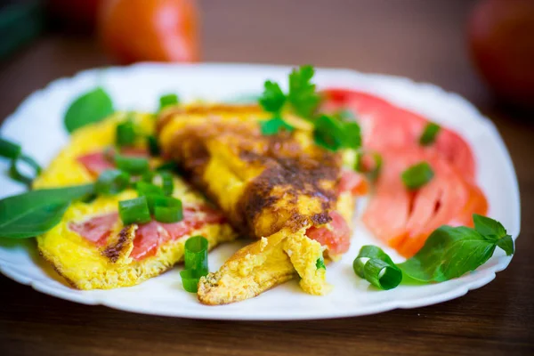 Omelete frito de ovos orgânicos caseiros com tomates e cebolas verdes — Fotografia de Stock