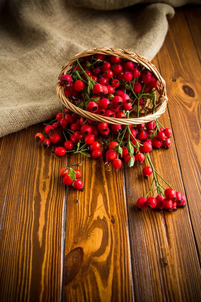 Reife rote Heckenrose in einem Korb auf einem hölzernen — Stockfoto