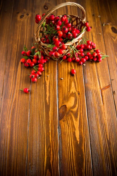 Ripe red dogrose in a basket on a wooden — Stock Photo, Image