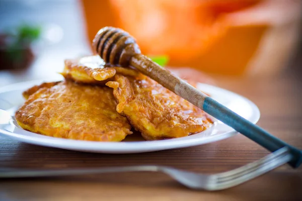 Tasty fried sweet pumpkin pancakes with honey — Stock Photo, Image