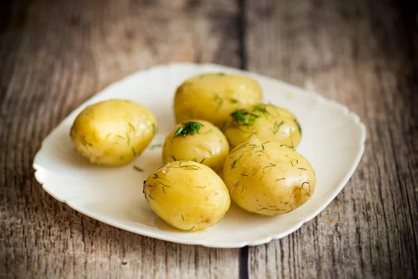 Ferveu a batata jovem com manteiga e endro em uma chapa — Fotografia de Stock