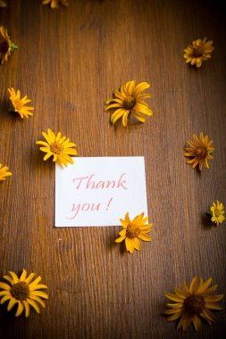 bir ahşap üzerinde sarı büyük papatyalar buketi