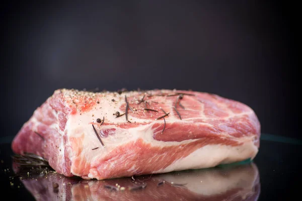 Trozo de carne de cerdo carne cruda con especias y romero en una oscuridad —  Fotos de Stock