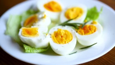 Tahta bir masada salata yapraklı haşlanmış yumurta.