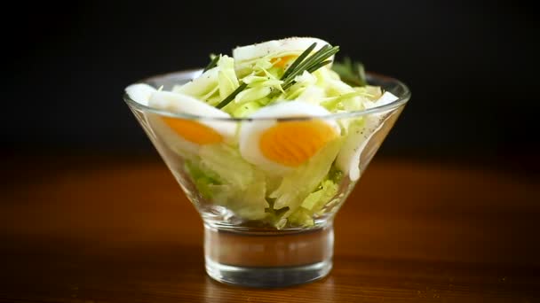 Ensalada fresca de primavera con repollo, lechuga y huevos cocidos con romero y especias — Vídeo de stock