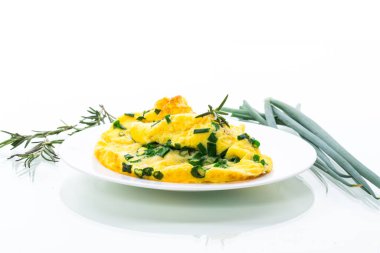 Beyaz arka planda izole edilmiş bir tabakta doğranmış yeşil soğanlı sıcak omlet.