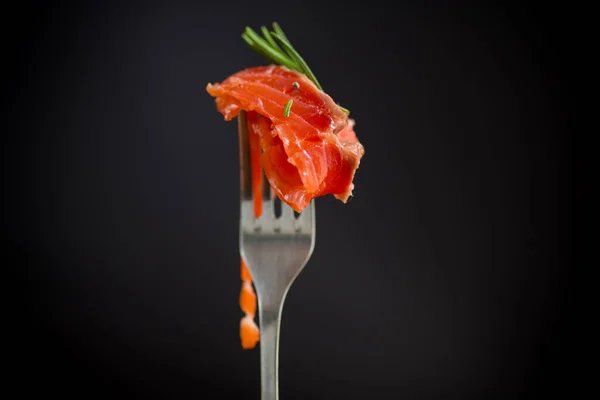 叉子上的咸红色鱼片 黑色背景 — 图库照片