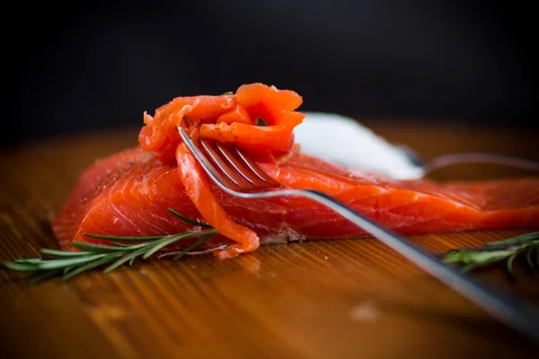 叉子上的咸红鱼片 木制背景 — 图库照片