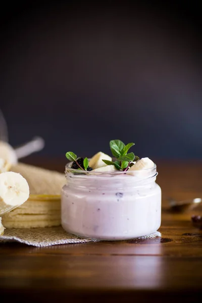 바나나 유리병에 건포도를 곁들인 맛있는 요구르트 — 스톡 사진