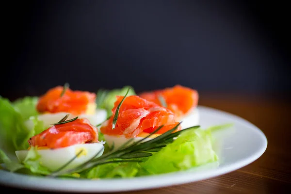 Kokta Ägg Med Saltad Röd Fisk Och Salladsblad Ett Träbord — Stockfoto