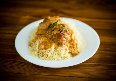 Ahşap bir masada et ve sos ile kaynatılmış vermicelli.