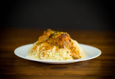 Ahşap bir masada et ve sos ile kaynatılmış vermicelli.