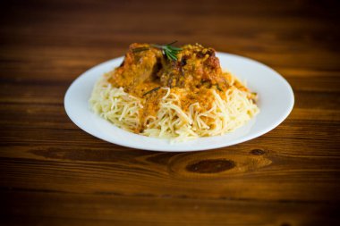 Ahşap bir masada et ve sos ile kaynatılmış vermicelli.