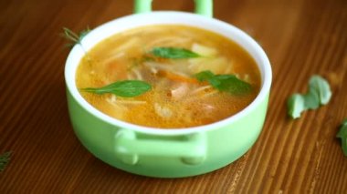 Vermicelli bahar çorbası, ahşap bir masada sebze ve otlar.