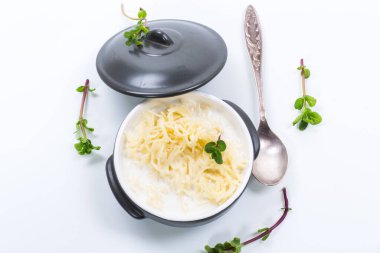 Beyaz arka planda izole edilmiş seramik bir kasede sütle kaynatılmış vermicelli.