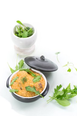 Kaynamış bulgur, seramik bir kasede sebze ve otlarla inliyor.