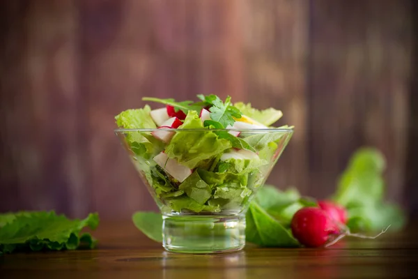 Весенний салат с рукколой, вареные яйца, свежая редиска, листья салата в стеклянной миске — стоковое фото