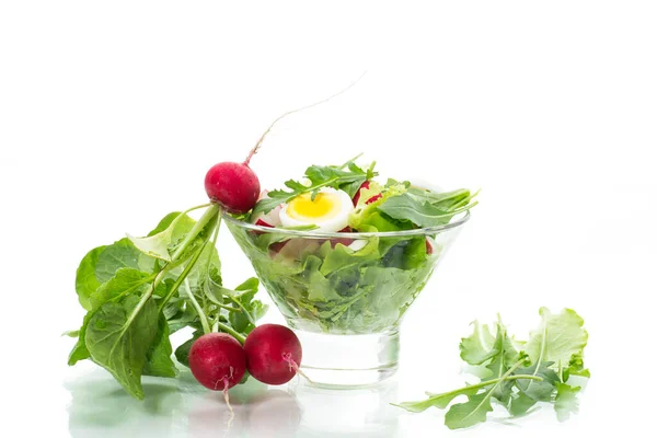 Весняний салат з руколою, вареними яйцями, свіжою редькою, листям салату у скляній мисці — стокове фото