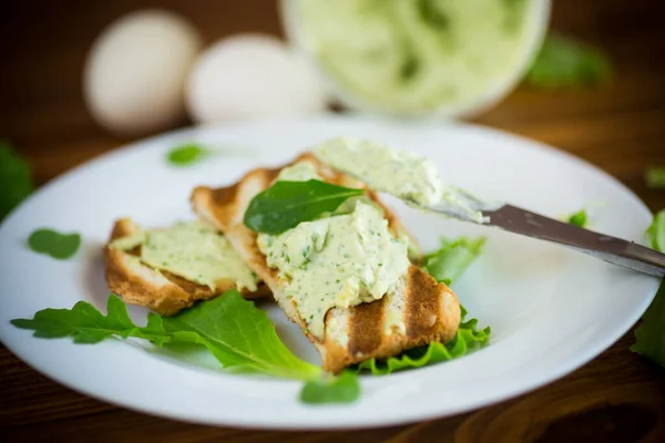 Green bread spread of arugula, curds and eggs with fried toast — Stock Photo, Image