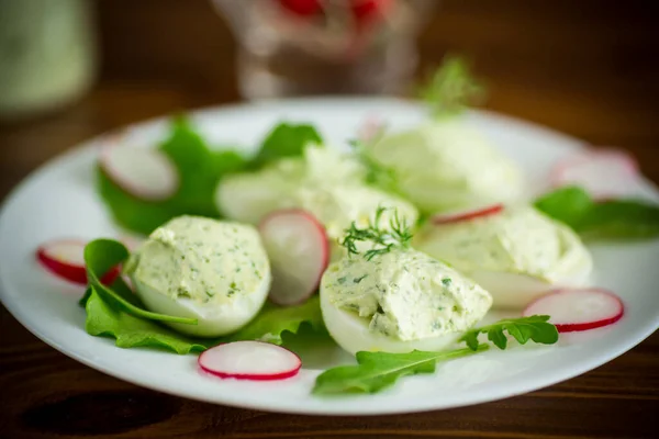 Gekochte gefüllte Eier mit grüner Käsefüllung mit Rucolablättern und Rettich — Stockfoto